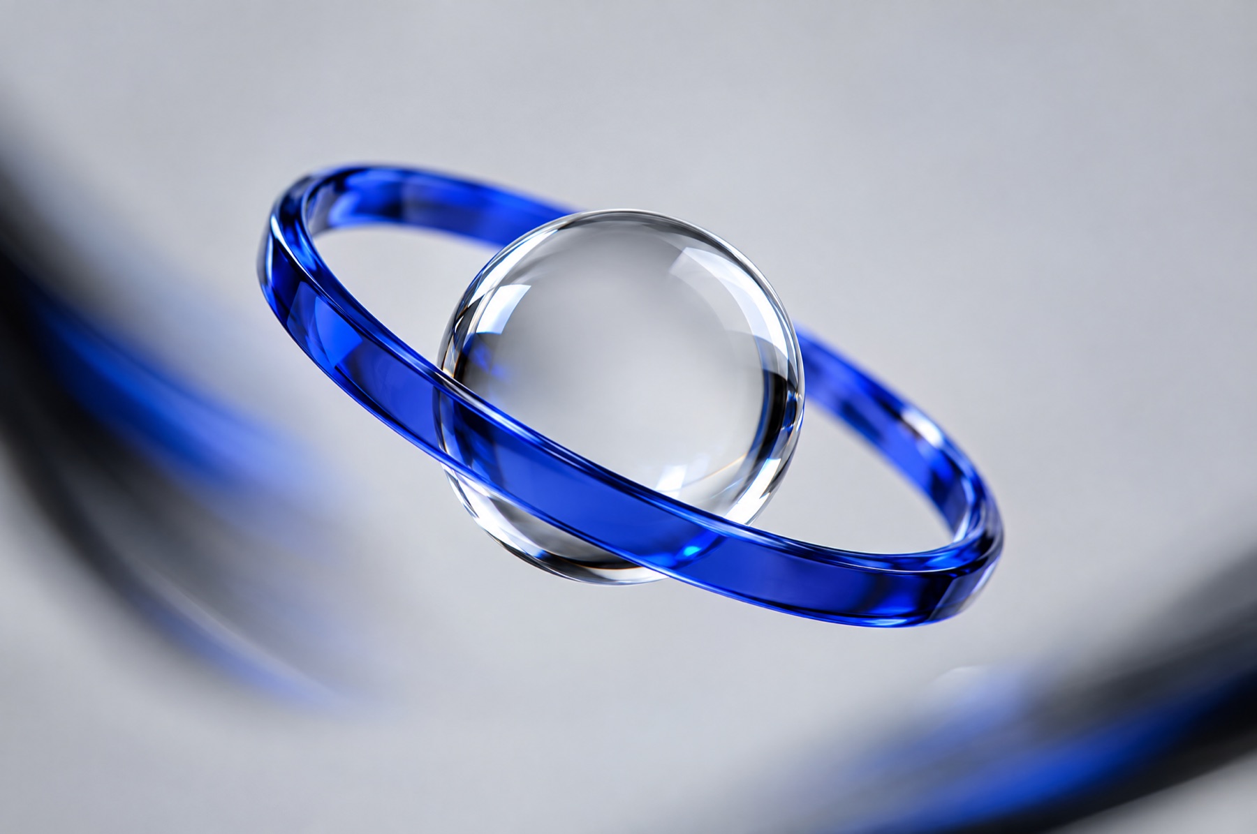 Eine feste klare Glaskugel wird von einem schräg stehenden blauen Glasring umkreist, als Sinnbild für eine gleichbleibende Brand Voice mit anpassbarem Ton.