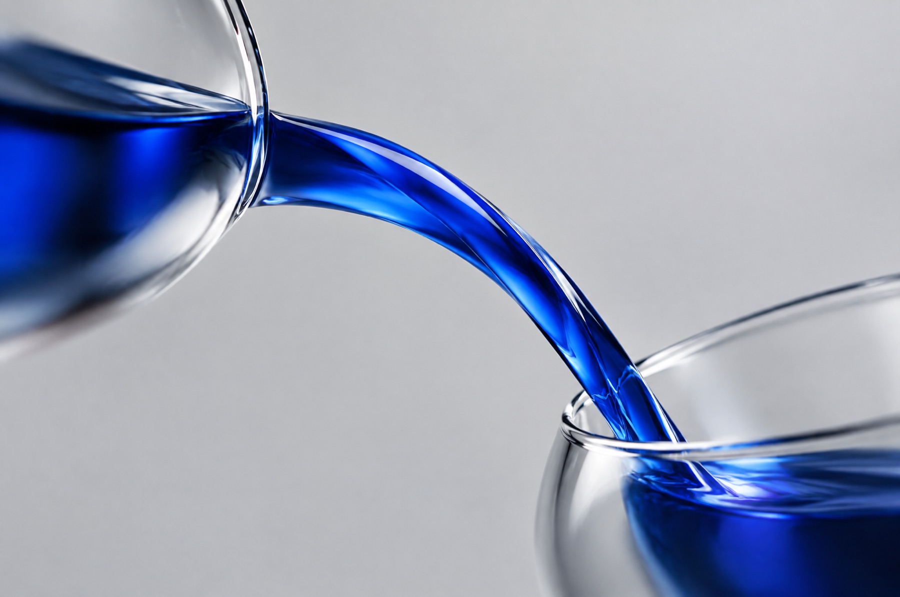 Blaue Flüssigkeit fließt in einem durchgehenden Bogen aus einem Glasgefäß in ein zweites als Sinnbild für eine Markenvorgabe, die beim Wechsel zum Plugin erhalten bleibt.