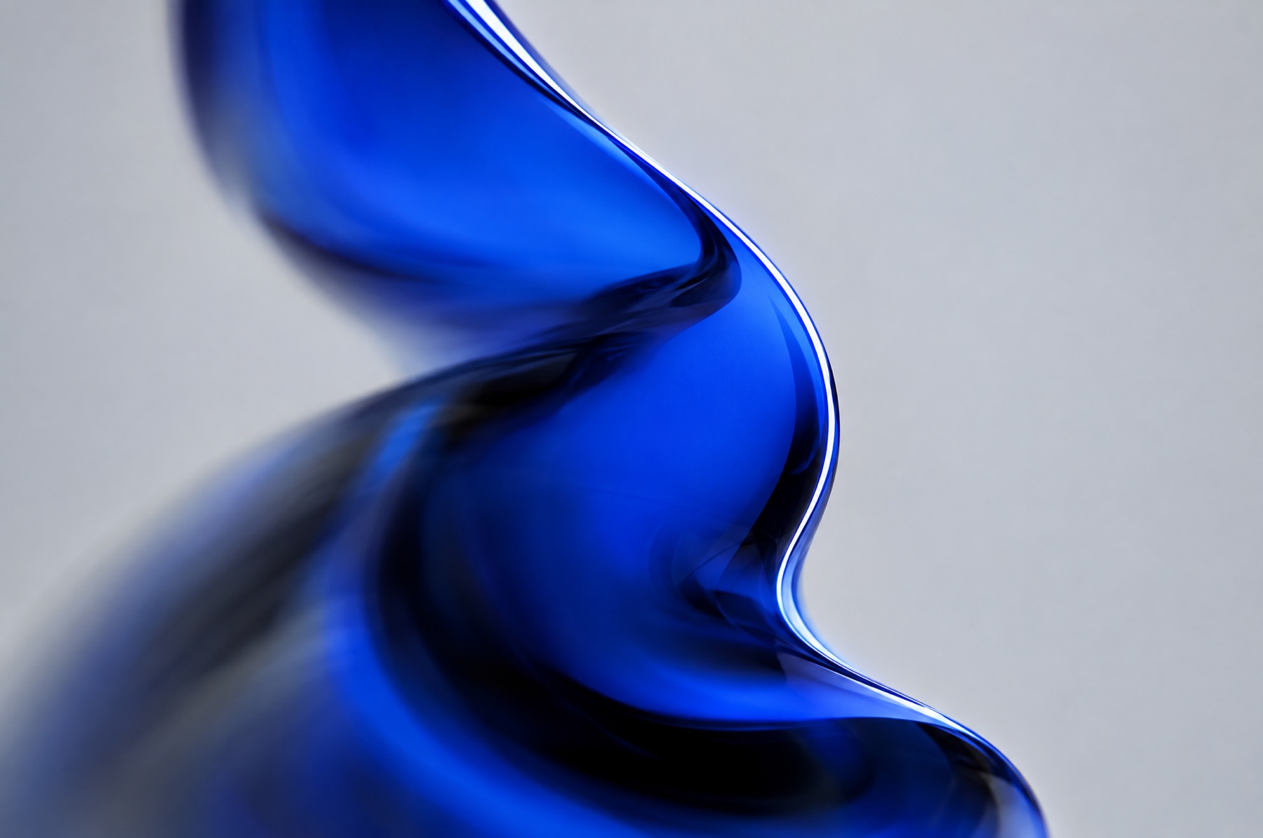 Eine einzelne, klar geformte blaue Glasform mit scharfer Lichtkante als Sinnbild für eine eindeutig definierte Marke.