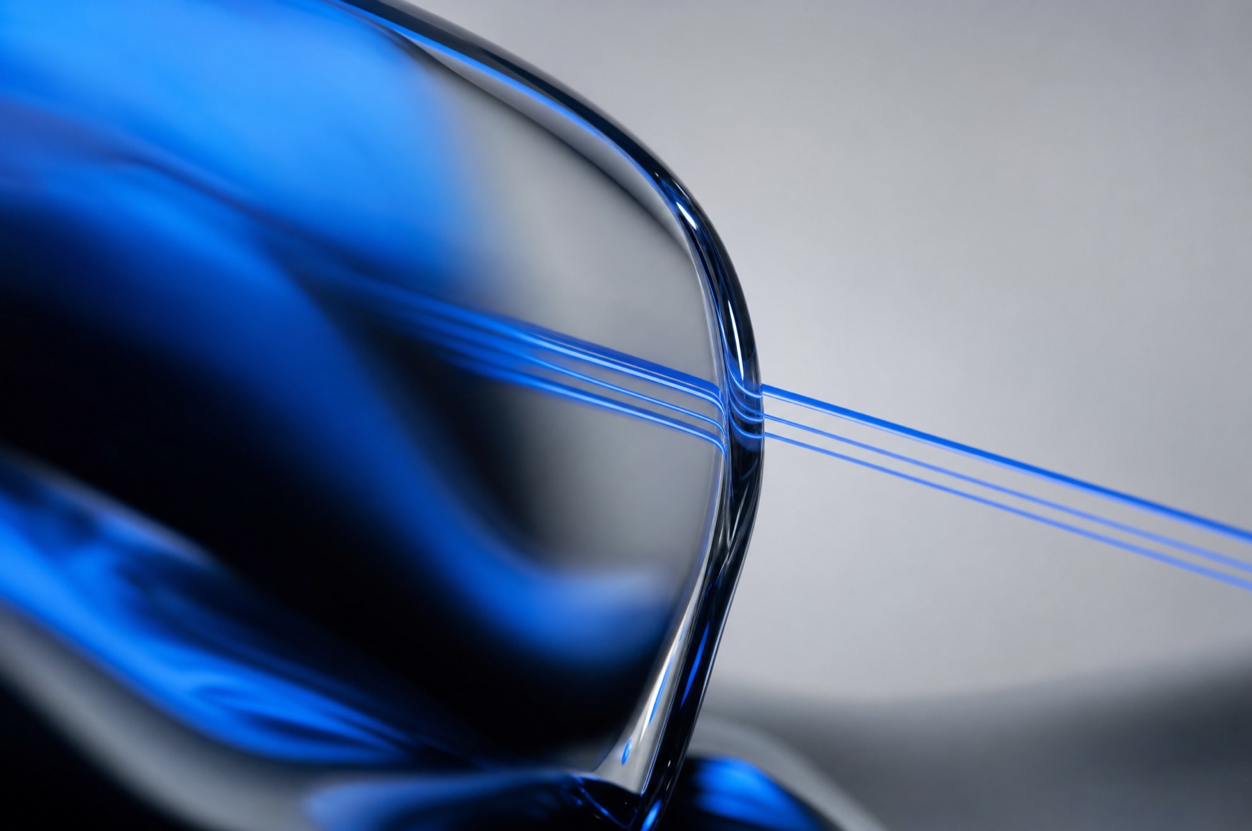 Feine blaue Lichtlinien laufen gerade durch eine Glasebene und setzen sich dahinter scharf fort als Sinnbild für eine Strategie, die KI anwenden kann.